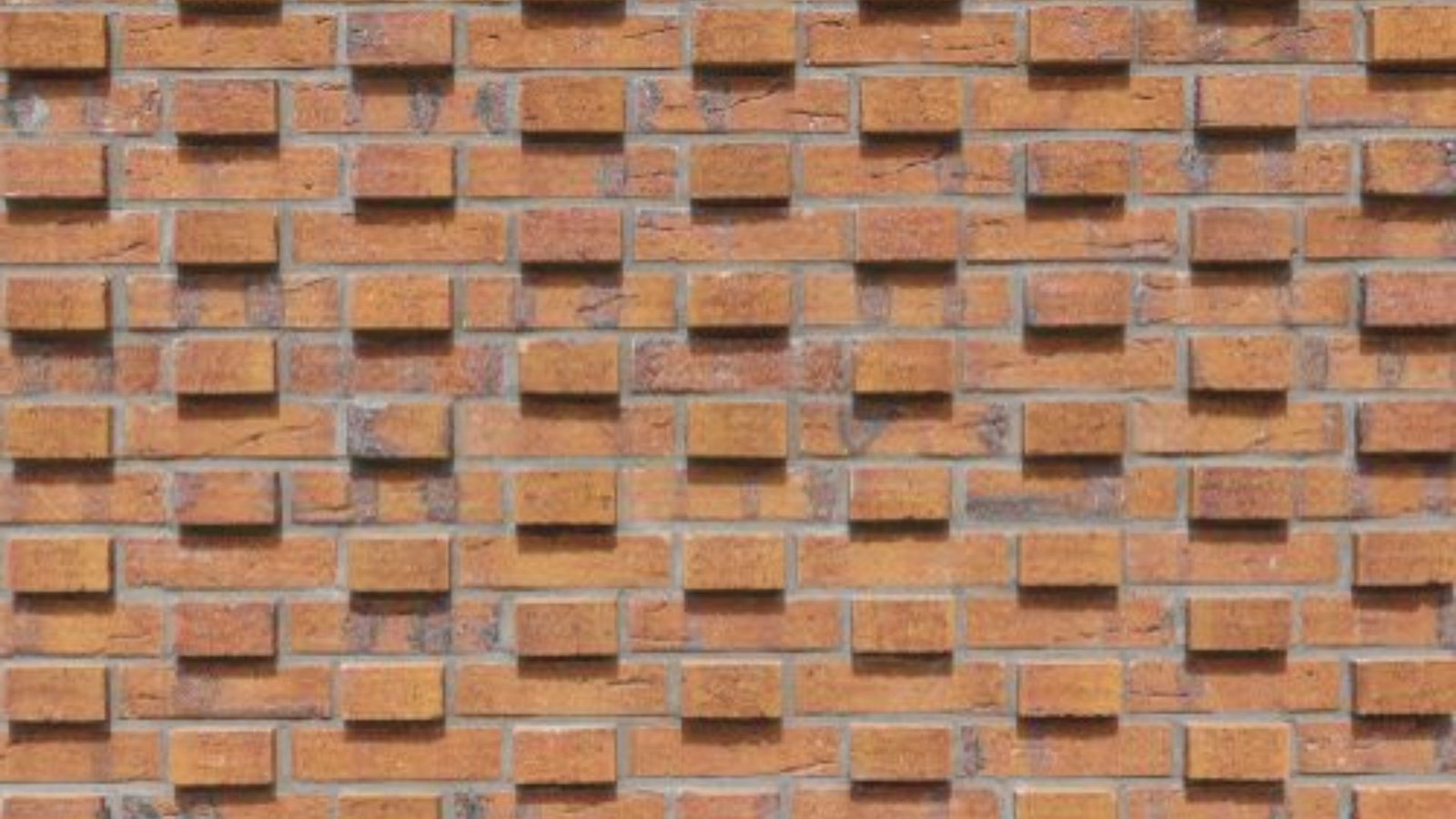 A textured brick wall featuring a pattern of evenly spaced squares throughout its surface.
