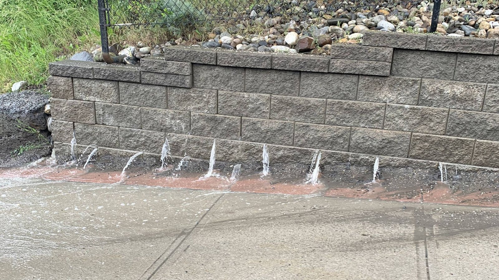 A water fountain cascades down the side of a textured wall, creating a serene and tranquil atmosphere.