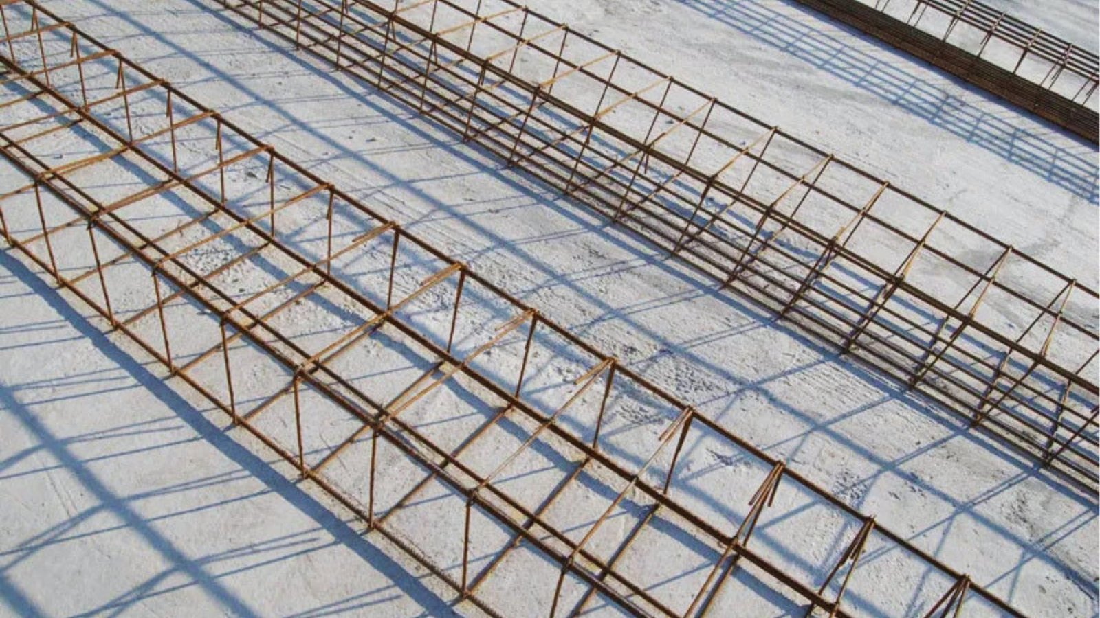 A large pile of metal rods scattered on the ground, showcasing various lengths and thicknesses.