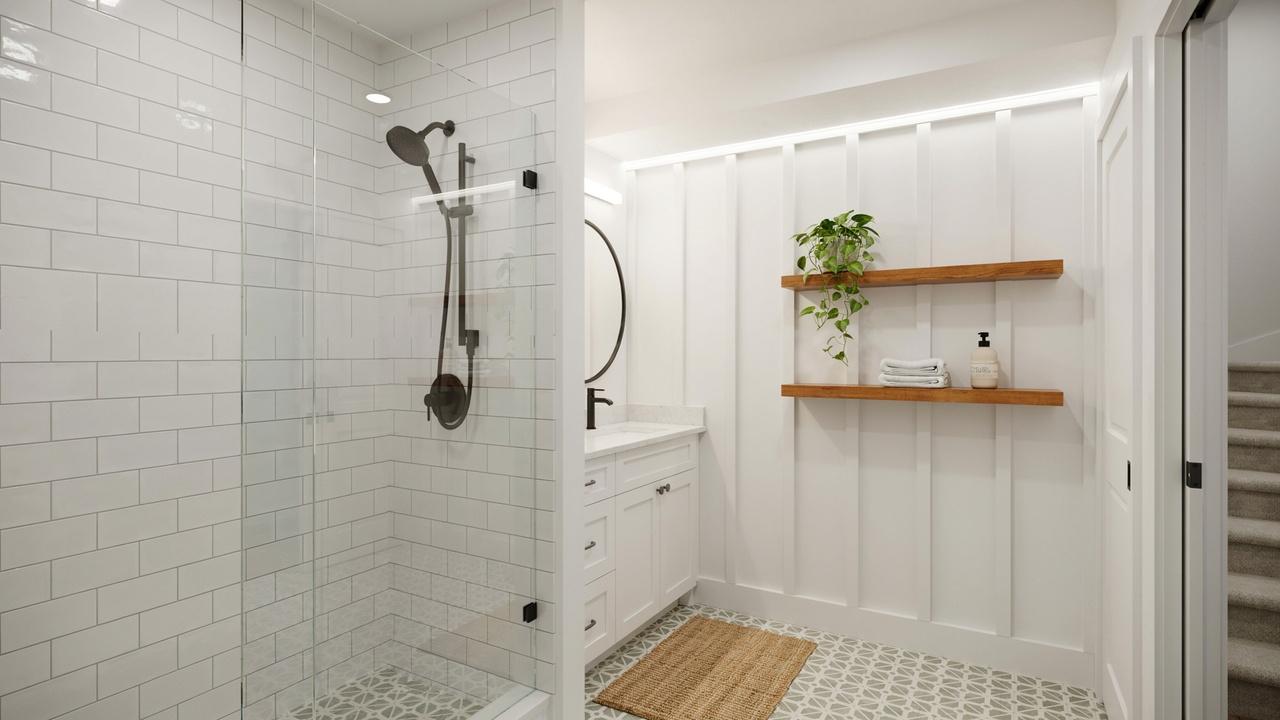 Budget-friendly unfinished basement bathroom with subway tile, patterned floor, and white vanity.