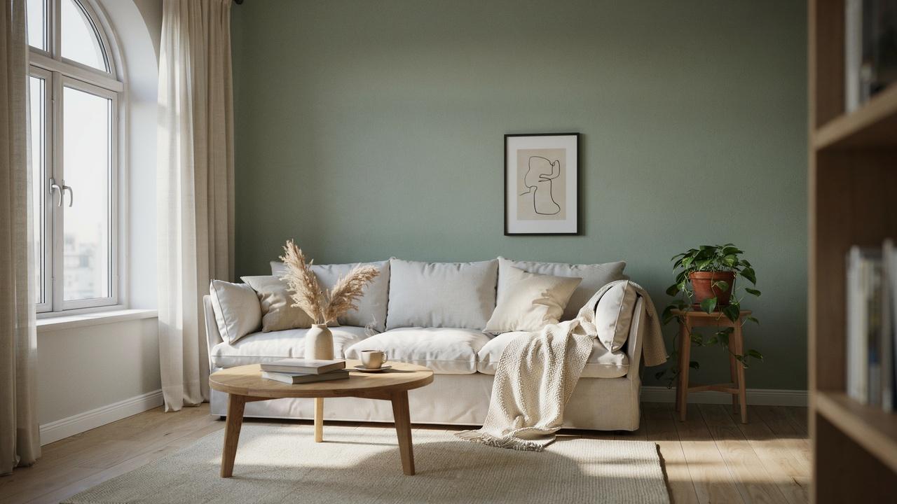 Living room with sage green walls, warm white furniture, and natural wood accents.