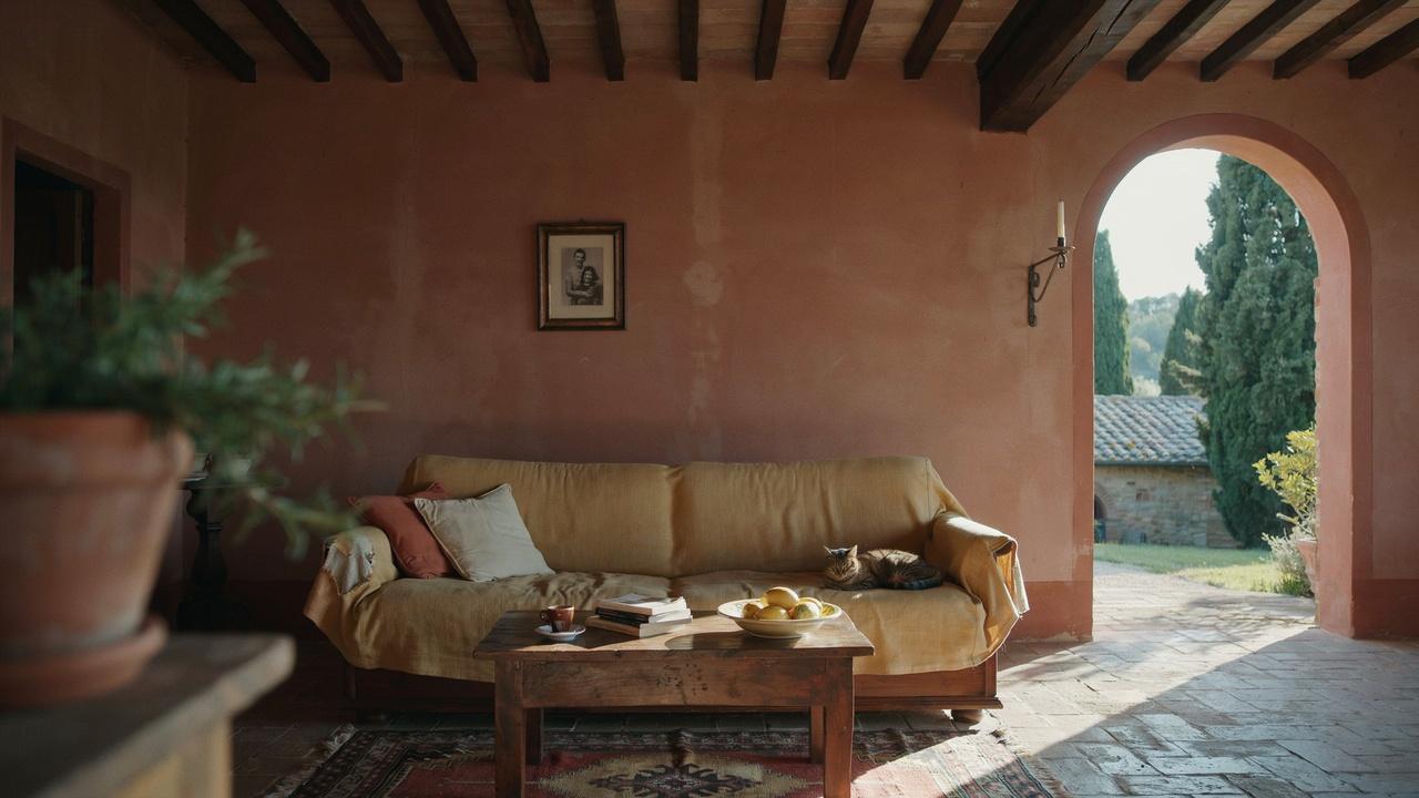 Italian Mediterranean interior with terracotta tones, arched doorways, rustic wood furniture, and a cozy villa feel.