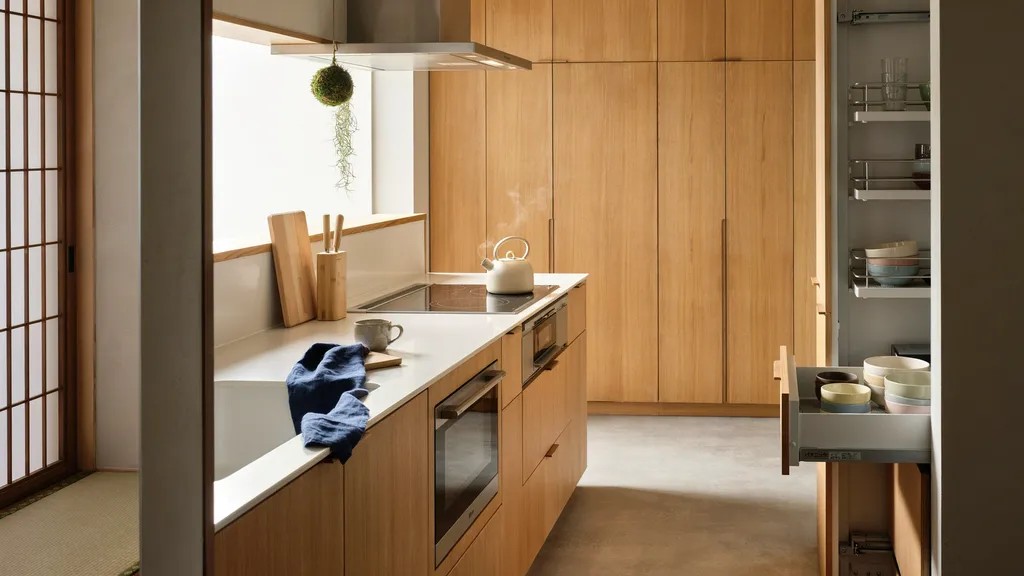 Small Japanese kitchen with vertical storage and space-saving minimalist design.