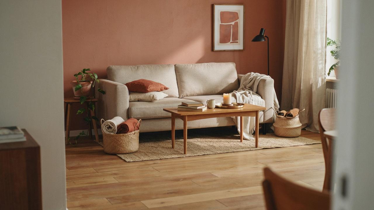 Living room with terracotta walls, sand-colored furniture, and natural woven decor.